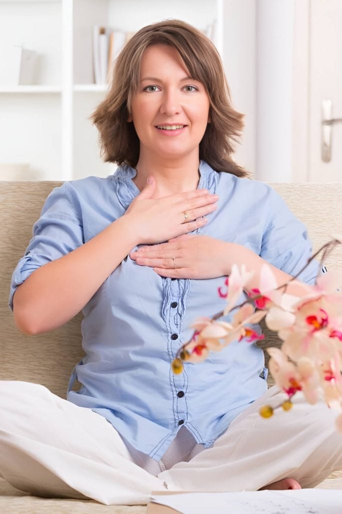Woman doing reiki healing on herself